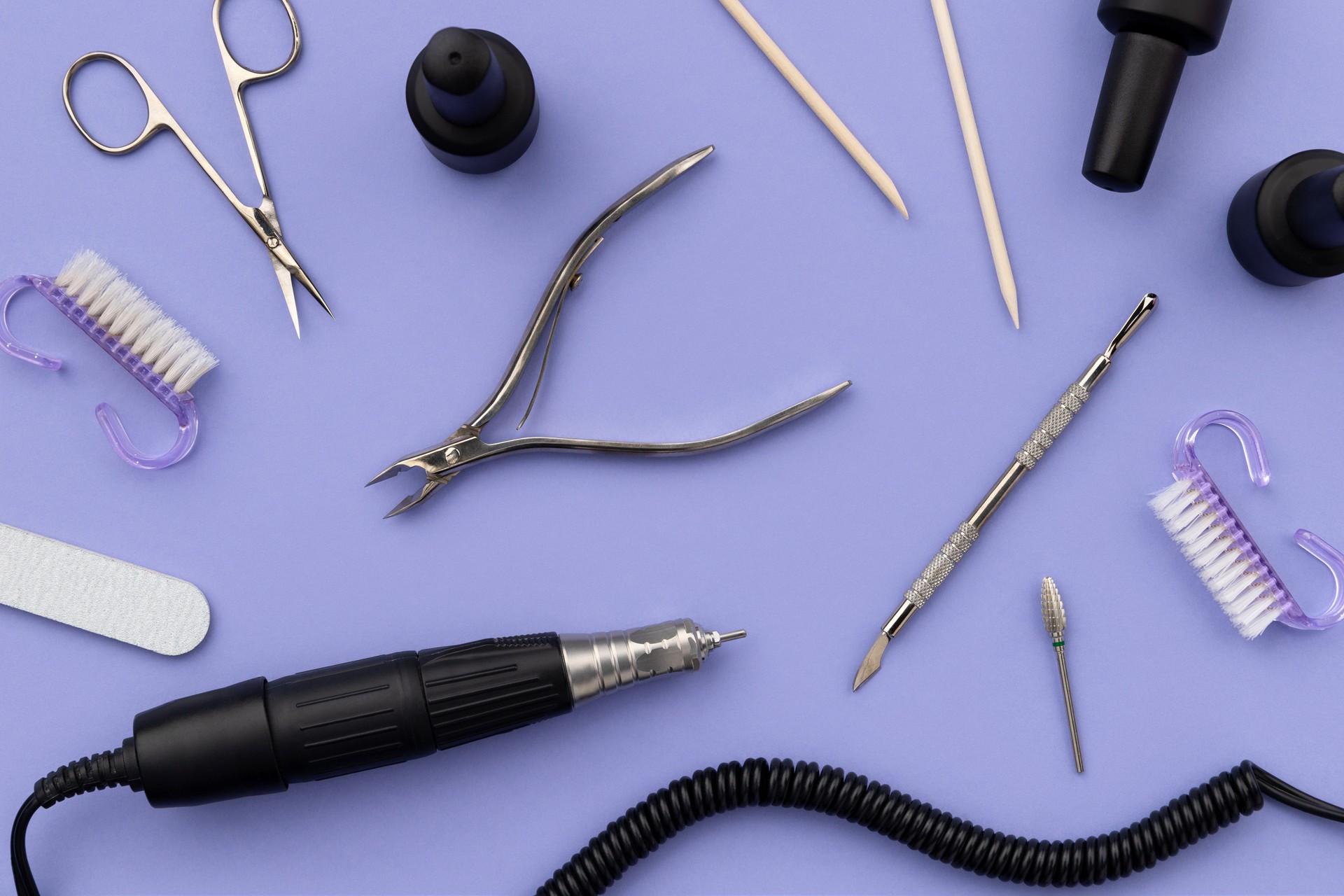 Set of cosmetic tools for manicure and pedicure on a purple background