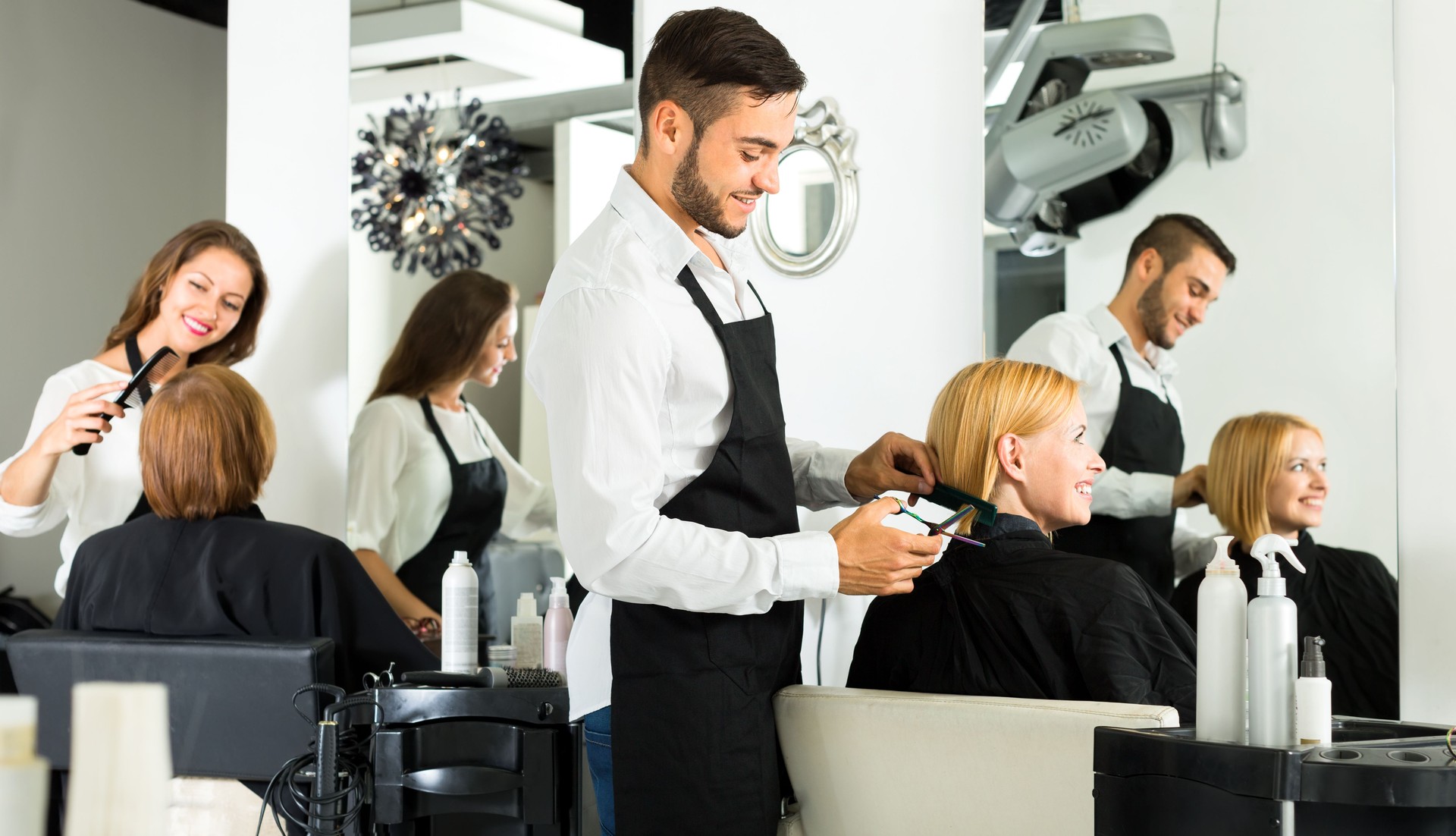 Hairdresser cutting hair on woman