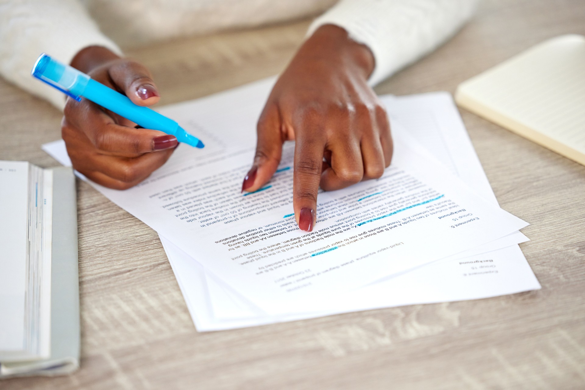 Shot of an unrecognisable woman making notes while studying at home